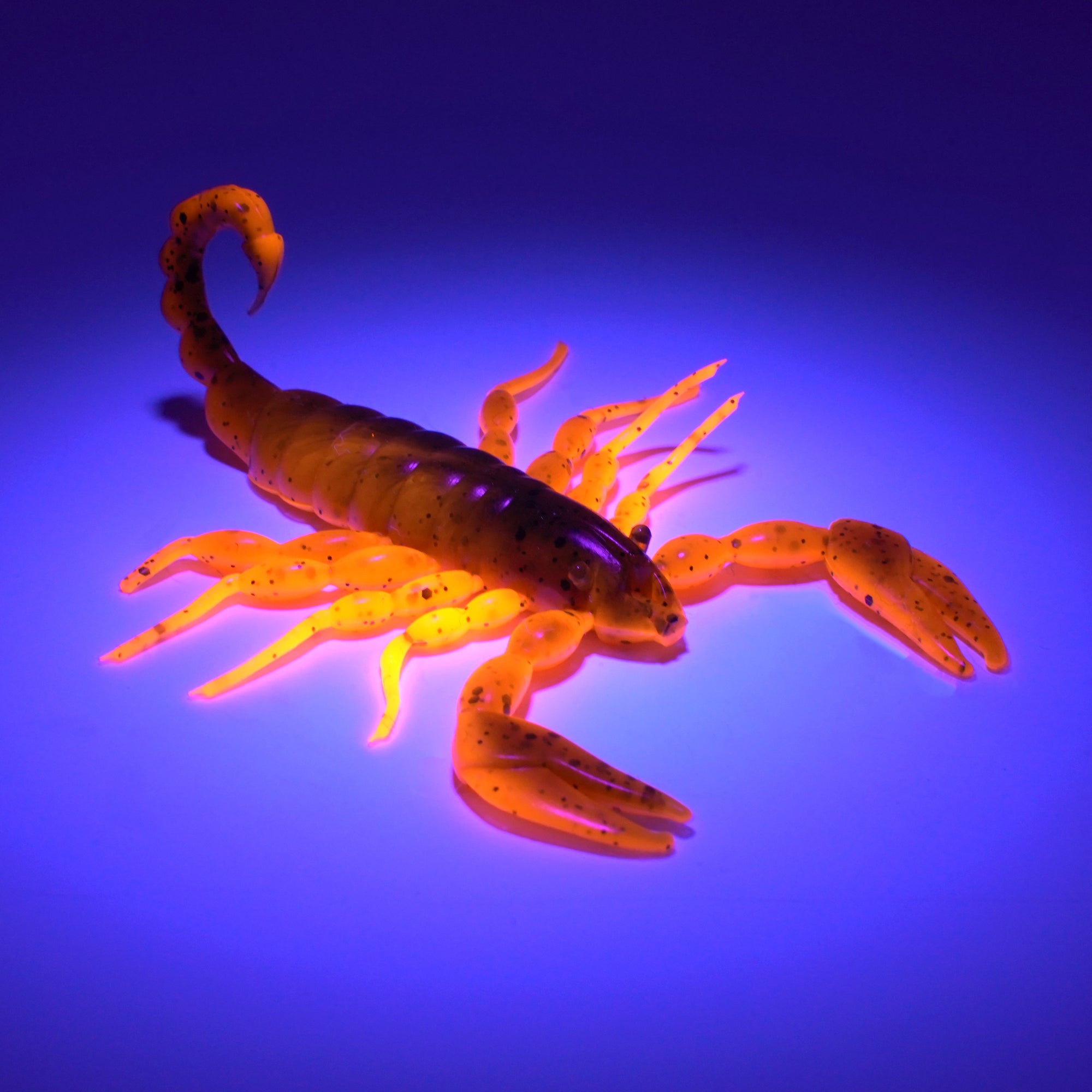 Green and orange soft plastic scorpion bait used for fishing under UV lighting. Fresh baitz alabama scorpion